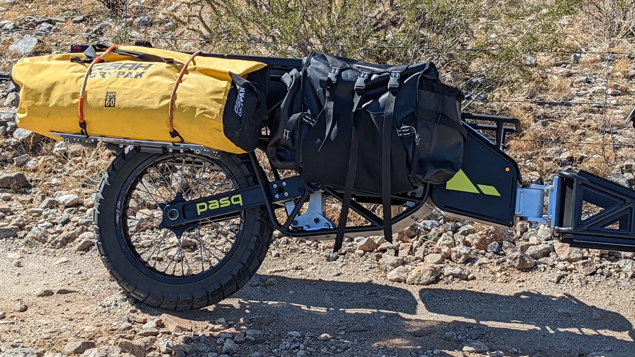 A Pasq ADV1, single-wheel dual-sport, adventure motorcycle trailer, loaded with a dry bag and a GiantLoop Round The World pannier.
