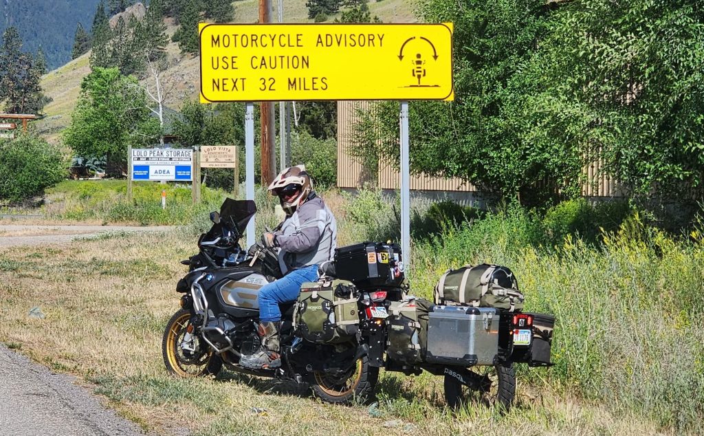 pasq rider confidently in front of motorcycle advisory sign